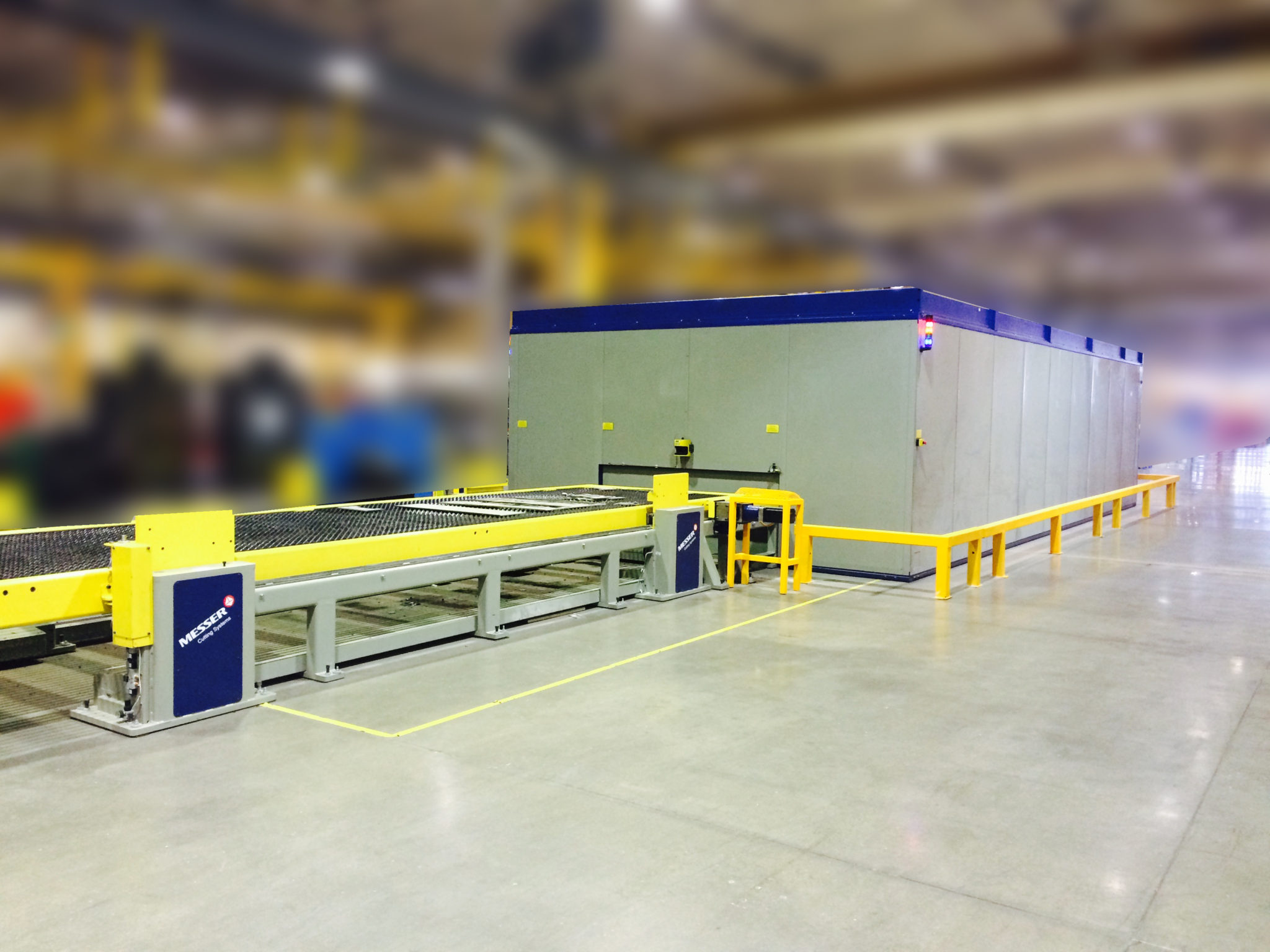 A shuttle table and in-line conveyor cutting table with an enclosure from Messer.